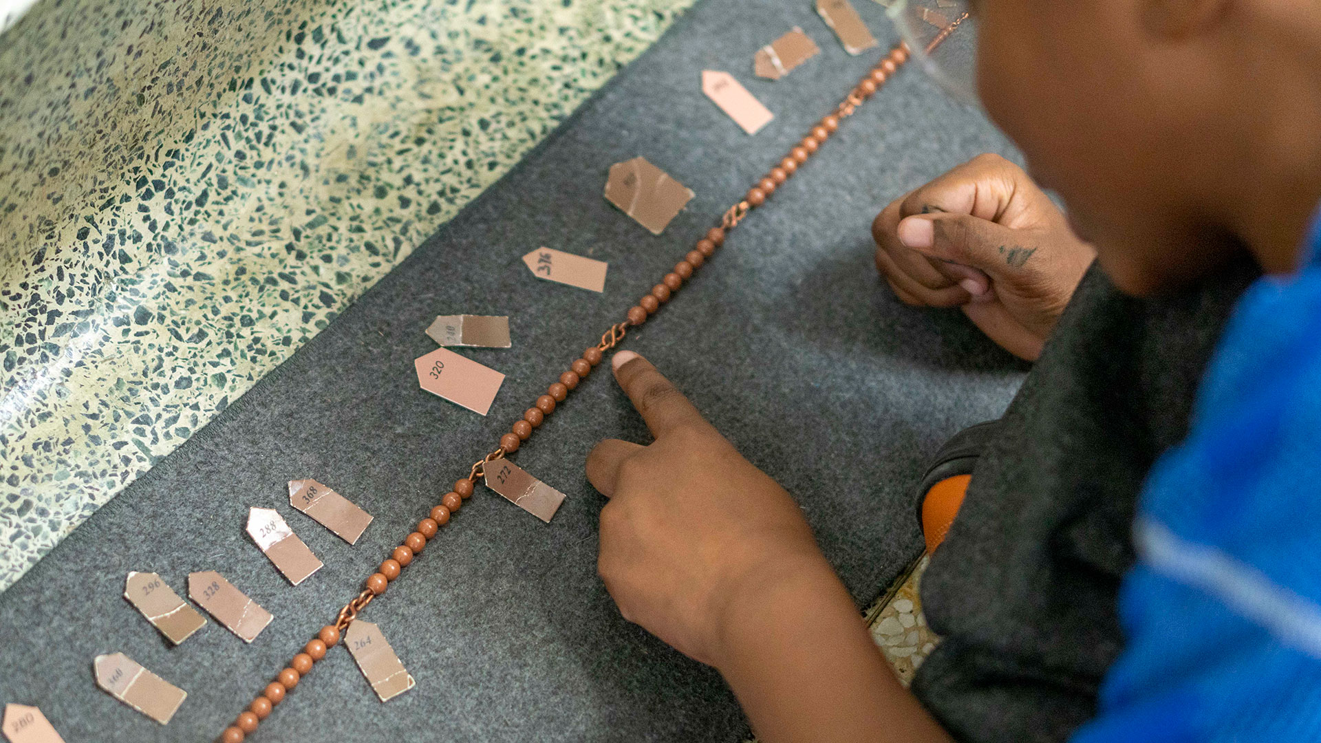A young student counts beads.