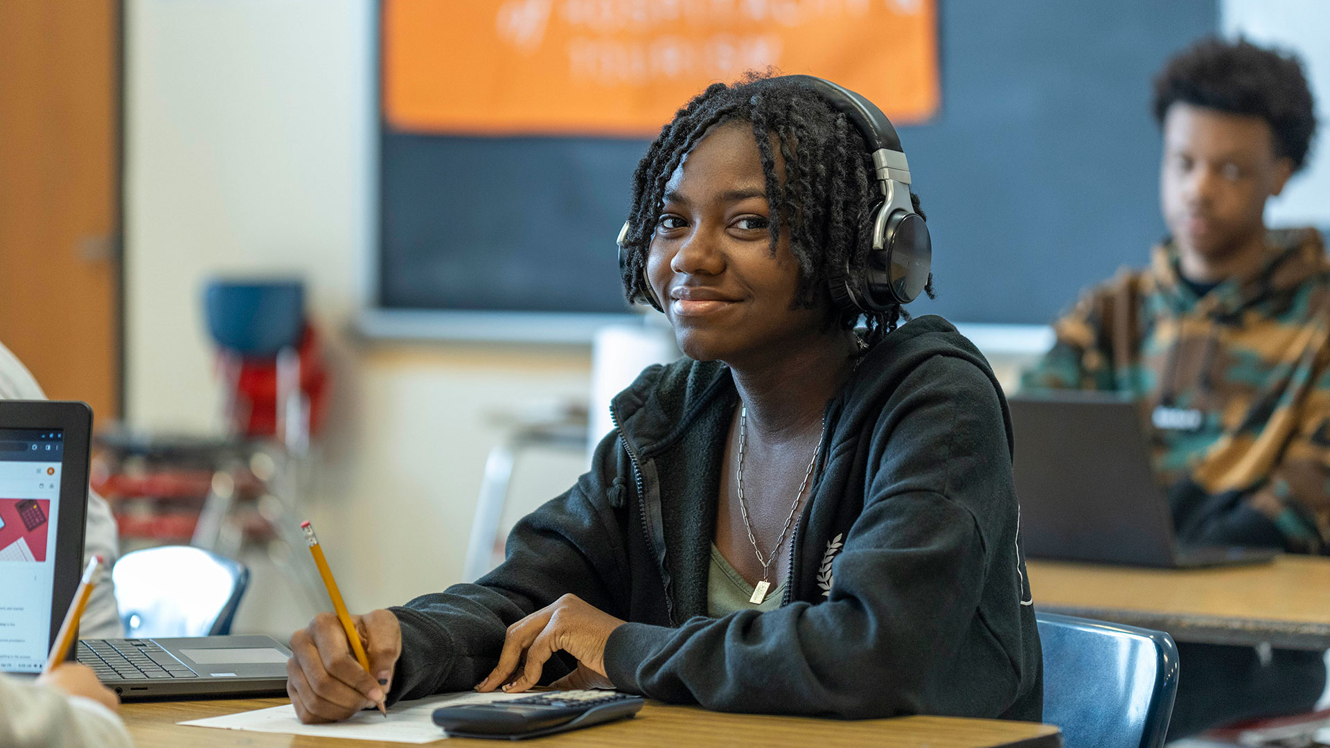 A student wearing headphones smiling.